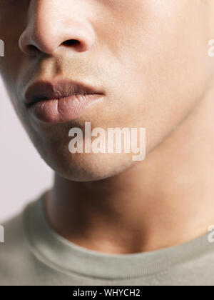 Primo piano del giovane americano africano uomo labbra su sfondo colorato Foto Stock