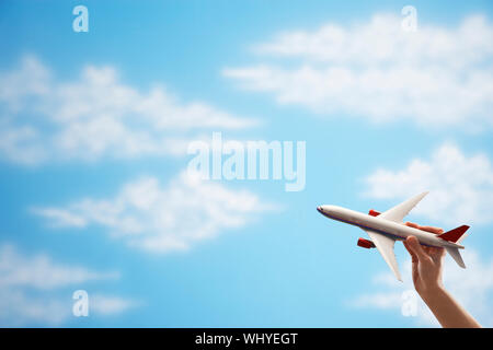 Primo piano della donna di mano battenti toy piano contro il cielo nuvoloso Foto Stock