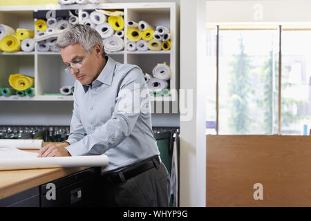 Uomo di mezza età studiando i documenti di office Foto Stock