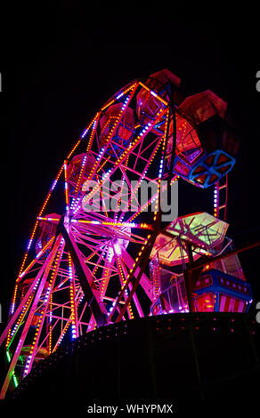 Ruota panoramica Ferris durante la notte con una luce rossa. Foto Stock