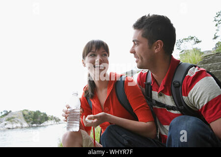 Allegro giovane donna waterbottle tenuta da un uomo all'aperto Foto Stock