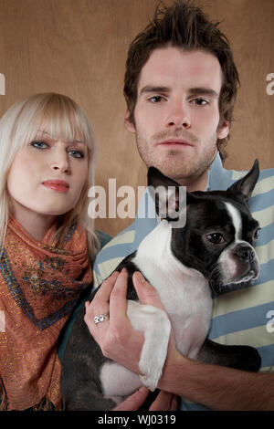 Ritratto di giovane coppia con bulldog francese su sfondo colorato Foto Stock