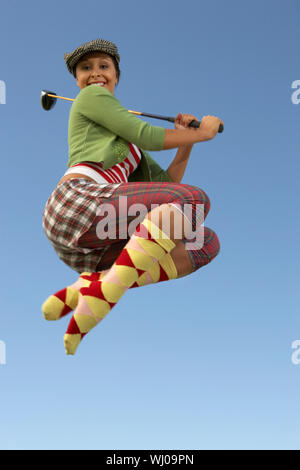 Ritratto di giovane donna salta con golf club Foto Stock