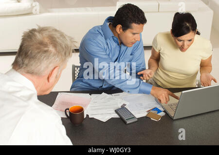 Elevato angolo di visione della società multietnica giovane con il senior advisor finanziario a casa Foto Stock