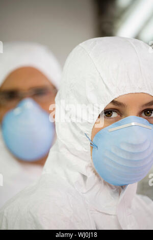 Ritratto di scienziati agricoli indossando maschera e tute da lavoro Foto Stock