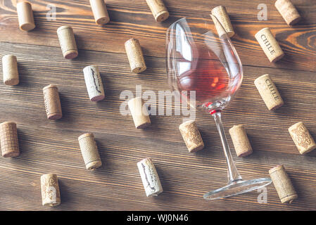 Bicchiere di vino rosso la posa su sfondo di legno Foto Stock