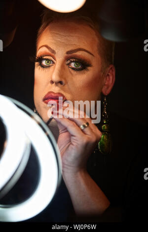 Caucasico gravi drag queen utilizzando il rossetto Foto Stock