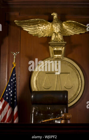 Vista dettagliata del giudice ha sede; bird; martello e la bandiera americana nella sala di corte Foto Stock