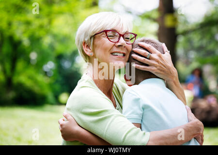 Felice la nonna con nipote abbracciando in un parco all'aperto Foto Stock