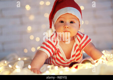 Baby's prima di Natale, ritratto su luci di partito Foto Stock