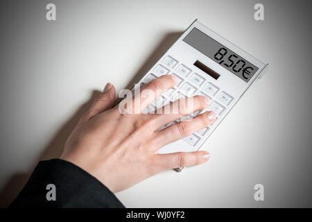 Femmina con mano calcolatrice, indicando la prevista tedesco salario minimo di 8,50 € Foto Stock