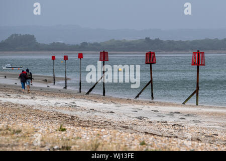 Linea di marcatori di spiaggia vicino al club di vela a Sandy Point a Hayling Island, Hampshire, Inghilterra Foto Stock