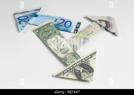Le frecce fatte di banconote piegato Foto Stock