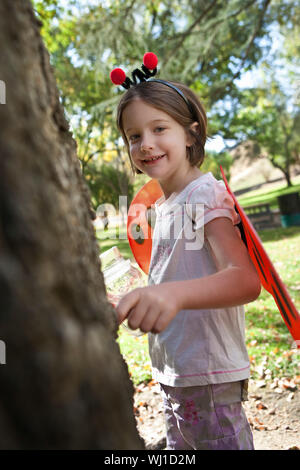 Ritratto di una ragazza sorridente in costume coccinella all'aperto Foto Stock