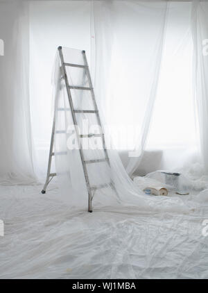 Stanza vuota coperti di polvere fogli preparati per pittura e decorazione Foto Stock