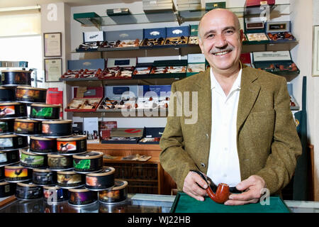 Ritratto di una felice coppia tabacco proprietario del negozio con le lattine sul display Foto Stock