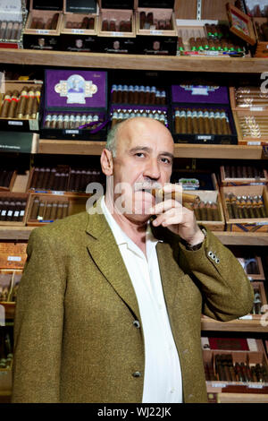 Ritratto di un uomo maturo di fumare il sigaro nel negozio di tabacco Foto Stock