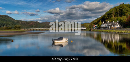 Panorama del legno di ponte a pedaggio, piscina e George terzo albergo a Penmaenpool in Snowdonia, il Galles del Nord. Una piccola barca in ormeggiata in primo piano. Foto Stock