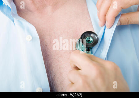 Primo piano di un maschio di medici di controllo a mano del paziente utilizzando heartbeat uno stetoscopio in clinica Foto Stock
