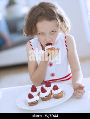 Ragazza giovane mangiare Cup cake Foto Stock