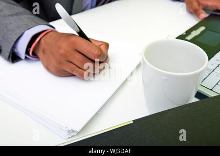 Close up di indiani mans mani scrittura su carta. Foto Stock