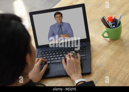 Donna d'affari che ha una videoconferenza su un portatile Foto Stock