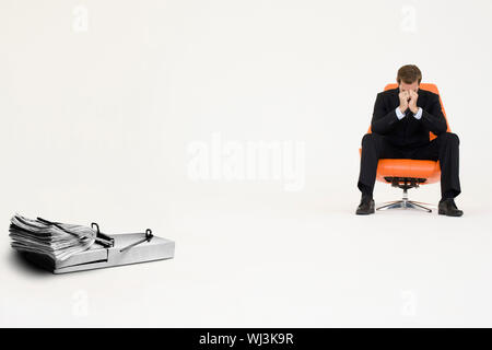 Tampone di denaro sul mouse trap con preoccupato imprenditore seduti su una sedia che rappresentano difficoltà finanziarie Foto Stock