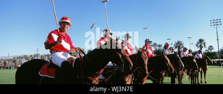 Panoramica dei giocatori di polo e arbitro su cavalli nel campo Foto Stock