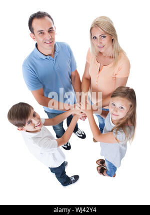 Vista in elevazione della famiglia mettendo le mani insieme isolato su sfondo bianco Foto Stock