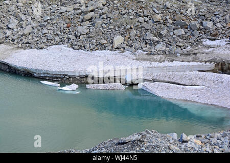 Lastre di ghiaccio rotto da un ghiacciaio in un lago glaciale in montagna come il clima si riscalda. Foto Stock