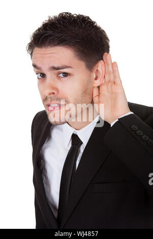 Imprenditore tenendo la mano al suo orecchio isolato su bianco Foto Stock