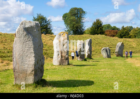 La gente a piedi in standing di Pietre di Avebury Stone Circle neolitico circolo di pietra di Avebury Wiltshire, Inghilterra UK GB Europa Foto Stock