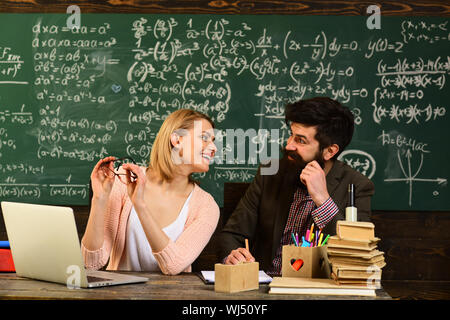 Gli studenti universitari che studiano con libri in biblioteca universitaria speaker maschio conduce la formazione aziendale, desiderio di aiuto dovrebbe essere il tutor da Foto Stock