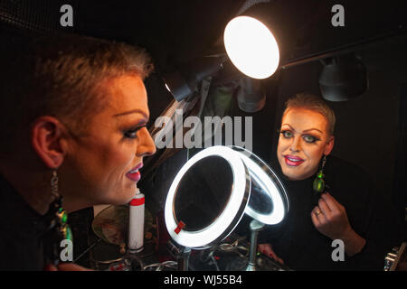 Caucasian drag queen a specchio in spogliatoio Foto Stock