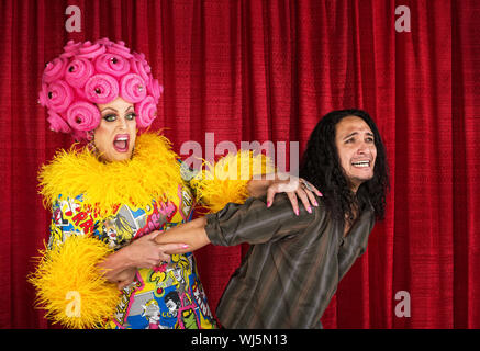 Emozionato cross-dressing regina tirando sulla paura l'uomo Foto Stock