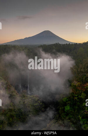 Antenna fuco immagine di Tumpak Sewu cascata con il monte Vulcano Semeru in background in Java Orientale, Indonesia Foto Stock