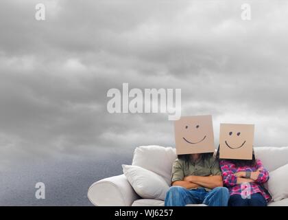 Immagine composita di silly dipendenti con i bracci ripiegati indossando le caselle sulle loro teste fluttuante nel cielo nuvoloso Foto Stock