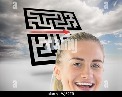 Immagine composita di ridere imprenditrice guardando la fotocamera nella parte anteriore del labirinto olografico nel cielo Foto Stock