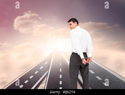 Immagine composita di imprenditore indossando le manette in piedi su strade fluttuante nel cielo Foto Stock