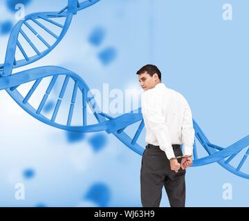 Immagine composita di imprenditore indossando le manette di fronte a spirale del DNA Foto Stock