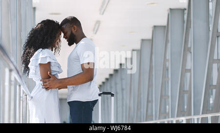 African American giovane cuddling in aeroporto prima della partenza del volo Foto Stock