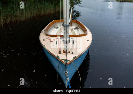 Vista ravvicinata di una vecchia imbarcazione a vela in vetroresina ancorato vicino alla riva. Foto Stock