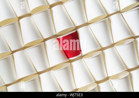 La configurazione di sfondo bianco di caffè bicchieri di carta con red cup in piedi fuori in mezzo. Orientamento diagonale, spazio di copia Foto Stock