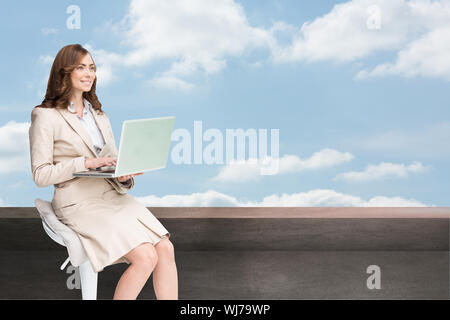 Immagine composita di sorridere imprenditrice seduta e utilizzo di computer portatile Foto Stock