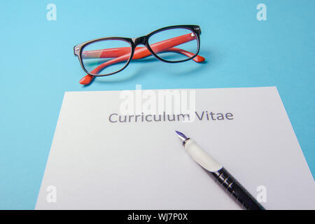 Curriculum vitae scritto su un vuoto di carta bianca su sfondo blu Foto Stock