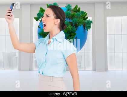 Immagine composita di angry classy imprenditrice a urlare contro il suo smartphone Foto Stock