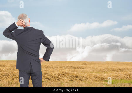 Immagine composita della vista posteriore di dubbia imprenditore maturo Foto Stock