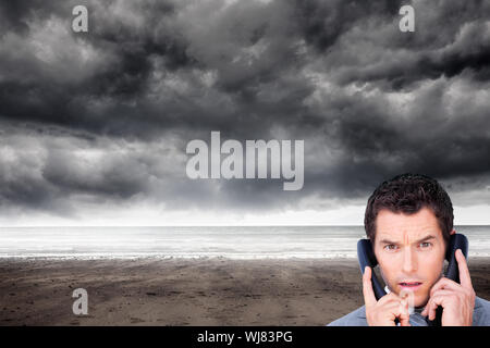 Immagine composita di angry businessman groviglio di fili del telefono isolato Foto Stock