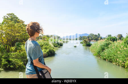 Donna che guarda al Fiume Mekong sulle isole 4000 Laos diurno, famosa destinazione di viaggio backpacker nel Sud Est asiatico Foto Stock