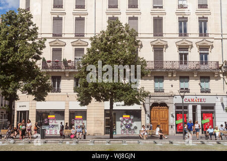 Lione, Francia - 13 luglio 2019: pedoni a piedi su Rue de la Republique Street a Lione, in Francia, di fronte a un stile Haussmann costruzione e alcune commercia Foto Stock